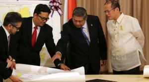 Indonesian President Susilo Bambang Yudhoyono, second from right, points at a map beside Philippine President Benigno Aquino III, right, during a signing ceremony at the Malacanang Presidential Palace in Manila, Philippines, Friday, May 23, 2014. The Philippines and Indonesia have signed an agreement resolving their sea border dispute after 20 years of negotiations as the leaders of the Southeast Asian neighbors vow to forge even closer ties. (AP Photo/Aaron Favila)
