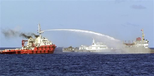 In this May 7, 2014 file photo released by Vietnam Coast Guard, a Chinese ship, left, shoots water cannon at a Vietnamese vessel, right, while a Chinese Coast Guard ship, center, sails alongside in the South China Sea, off Vietnam's coast as Chinese ships are ramming at Vietnamese vessels trying to stop Beijing from setting up an oil rig in the sea. AP FILE PHOTO