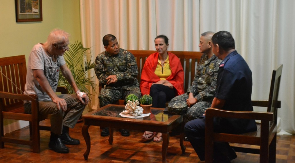 In this photo released by the Armed Forces of the Philippines, kidnapped German nationals Stefan Okonek, left, and female companion Henrike Dielen, center, rest inside the Western Mindanao Command in Zamboanga city in southern Philippines, Saturday, Oct. 18, 2014, after they were freed from the hands of the Muslim extremist group the Abu Sayyaf. Okonek and Dielen, who had been kidnapped and held for six months in the southern Philippines were released Friday by the militant group just hours after it had threatened to behead one of them if no ransom payment was made, the Philippine defense chief said. (AP Photo/Armed Forces of the Philippines Western Mindanao Command)