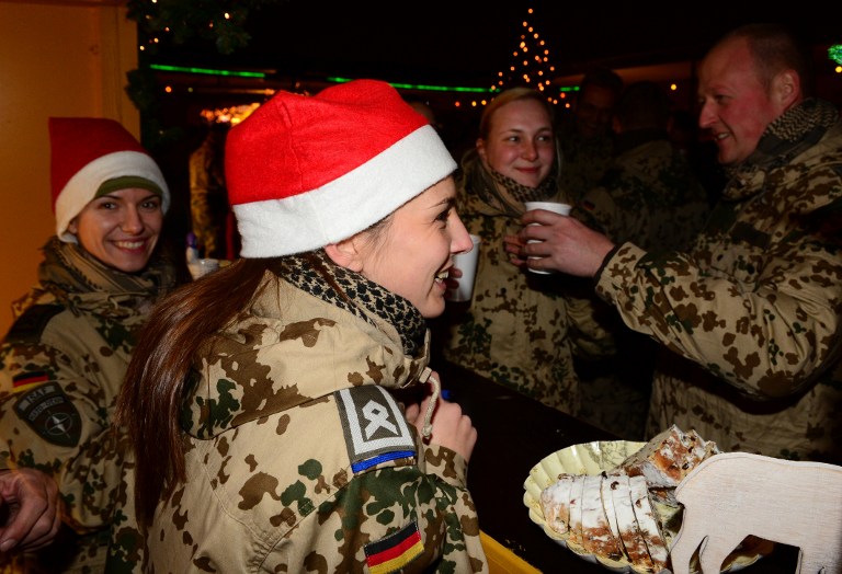 German soldiers serve mulled wine at a Christmas Market in Camp Marmal in Mazar-e Sharif on December 13, 2014.  AFP