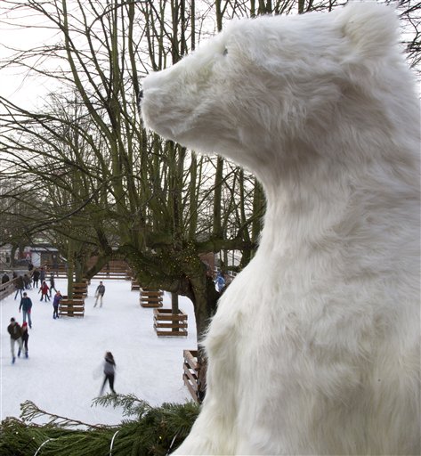 A stuffed polar bear overlooks a skating rink on the Christmas market in Antwerp, Belgium on Sunday, Dec. 14, 2014. AP