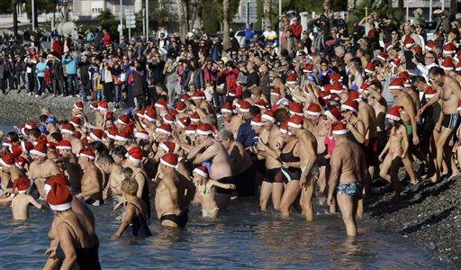 People go swimming during the traditional Christmas bath in the Mediterranean sea at Cagnes sur Mer, near Nice, southeastern France, Sunday, Dec. 7, 2014.  Around 350 swimmers take part in the annual swim. AP