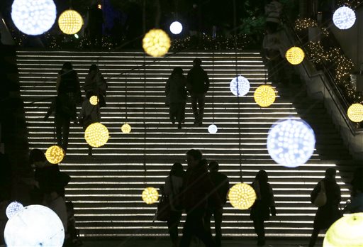 In this Saturday, Dec. 6, 2014 photo, visitors walk through Christmas lights at Tokyo Dome City in Tokyo.  AP