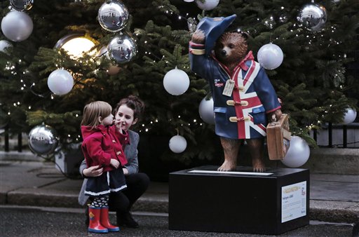 A child looks at a statue of the Paddington bear, outside British Prime Minister David Cameron's official residence at 10 Downing Street, in central London, as children and their families arrive for the charity Christmas party, Monday, Dec. 15, 2014.
