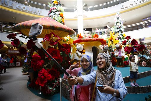 Muslim women pose for selfie in front of Christmas decorations at a shopping mall in Malaysia Wednesday, Dec. 10, 2014. Shopping malls in Muslim-dominated Malaysia have been decorated with Christmas trees, lights and Santa Claus to attract year-end shoppers. AP