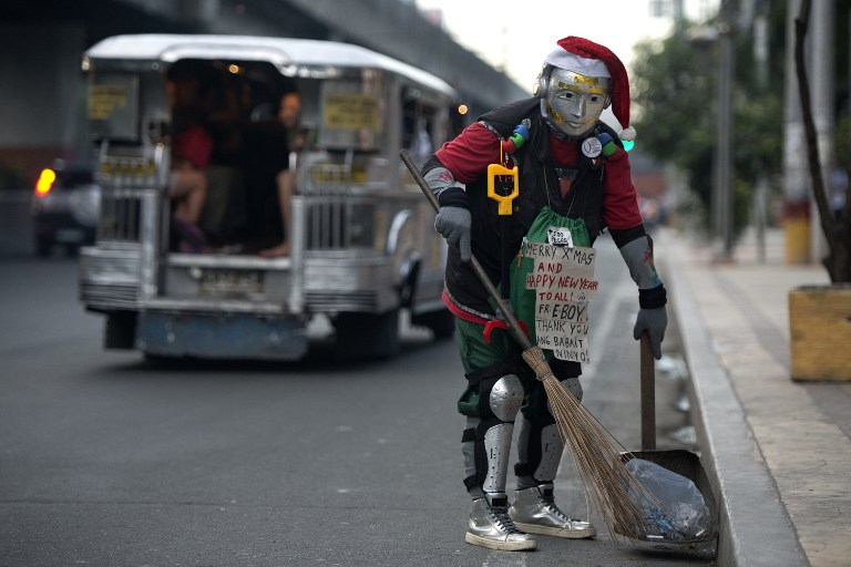 A street sweeper dressed as a robot Santa Claus cleans a street in Manila on December 18, 2014. The Philippines is the largest Christian country in Asia and has one of the longest Christmas seasons in the world, lasting from December 16 to January 6. AFP