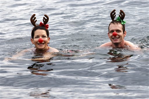 Participants of the 76th edition of the annual Christmas swimming "Coupe de Noel" enjoy swimming in  Lake of Geneva, in Geneva, Switzerland, Sunday, Dec. 14, 2014. More than 1500 men and women swam the 120 meters at the traditional Christmas swimming in Geneva. AP