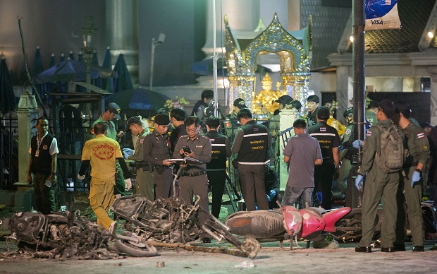 Police investigate the scene at the Erawan Shrine after an explosion in Bangkok,Thailand, Monday, Aug. 17, 2015. A large explosion rocked a central Bangkok intersection during the evening rush hour, killing a number of people and injuring others, police said(AP Photo/Mark Baker)