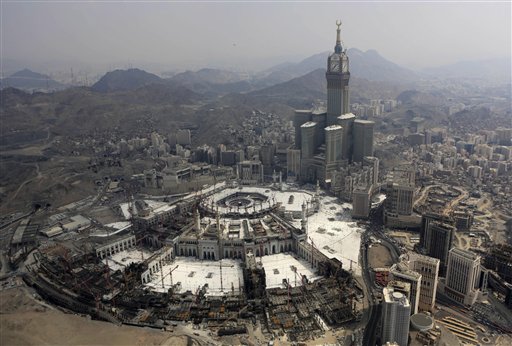 In this Sunday, Oct. 5, 2014 file photo, the Abraj Al-Bait Towers with the four-faced clocks stands over the holy Kabaa, as Muslims encircle it inside the Grand Mosque during the annual pilgrimage, known as the hajj, in the Muslim holy city of Mecca, Saudi Arabia. Saudi Arabia's civil defense authority says dozens of people have been killed after a crane collapsed on the Grand Mosque in the holy city of Mecca on Friday, Sept. 11, 2015. AP