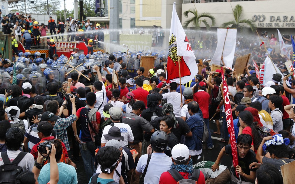 Police fire water cannons at student activists as they clash near the venue hosting the Asia-Pacific Economic Cooperation (APEC) summit in Manila, Philippines, Thursday, Nov. 19, 2015. Asia-Pacific leaders called Thursday for increased international cooperation in the fight against terrorism as they held annual talks overshadowed by the Paris attacks. (AP Photo/Wally Santana)