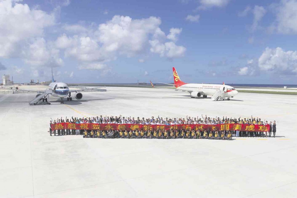 COMMERCIAL PLANES LANDONKAGITINGAN Passengers and crew of a Hainan Airlines plane and a China SouthernAirlines plane pose for a souvenir photo on Kagitingan (Fiery Cross) Reef in the Spratlys that China has transformed into an airfield. The ChinaDaily newspaper said the two planes made the two-hour flight to the reef from Hainan province on Jan. 6. XINHUA/AP