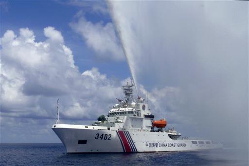 In this Sept. 23, 2015, photo, provided by Filipino fisherman Renato Etac, a Chinese Coast Guard boat sprays a water cannon at Filipino fishermen near Scarborough Shoal in the South China Sea. A landmark ruling on an arbitration case filed by the Philippines that seeks to strike down China's expansive territorial claims in the South China Sea will be a test for international law and world powers. China, which demands one-on-one talks to resolve the disputes, has boycotted the case and vowed to ignore the verdict, which will be handed down Tuesday, July 12, 2016, by the U.N. tribunal in The Hague. (Renato Etac via AP)