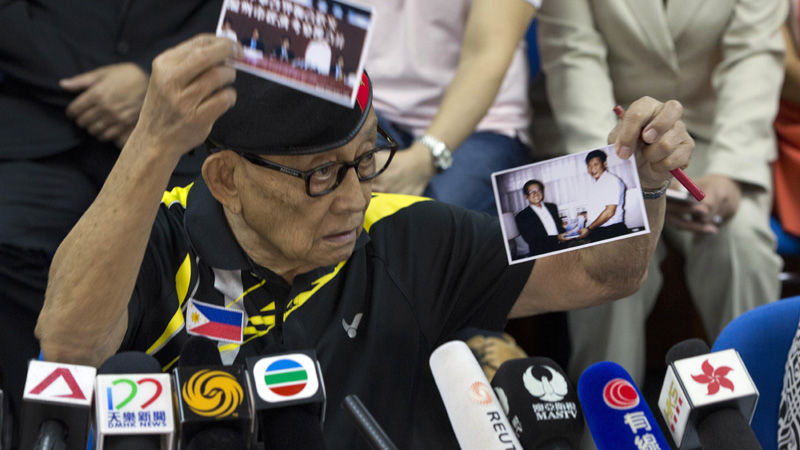 Former Philippine President Fidel Ramos holds up what he says are photos of Chinese President Xi Jinping when he visited the Philippines in his youth during a press briefing at the Philippines consular office in Hong Kong, China, Tuesday, Aug. 9, 2016. Former Philippine President Fidel Ramos flew to Hong Kong on Monday for talks aimed at rekindling ties with China that have been strained by long-seething disputes in the South China Sea.(AP Photo/Ng Han Guan)