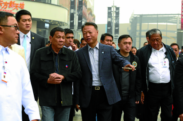 President Rodrigo Duterte is joined by Chinese Ambassador to the Philippines Zhiao Jianhua as they walk along Wangfujing Street in Beijing China going to Dadong Roast Duck Restaurant for a lunch on October 19. Also in the photo are Special Assistant to the President Christopher Go and Transportation Secretary Arthur Tugade. KING RODRIGUEZ/Presidential Photo