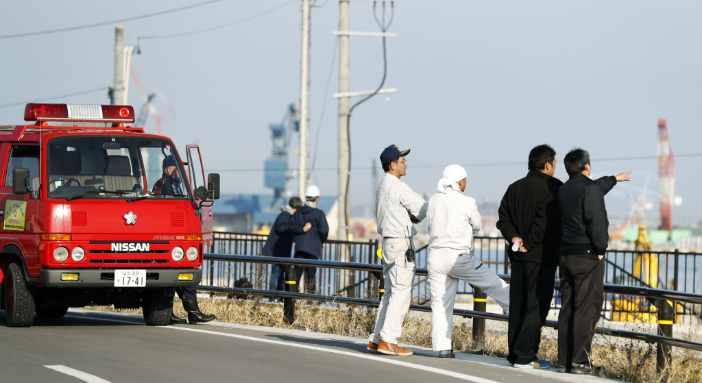 Firefighters and others watch the port to check the water level as a tsunami warning is issued following an earthquake in Soma, Fukushima prefecture, northern Japan, Tuesday, Nov. 22, 2016. Coastal residents in Japan were ordered to flee to higher ground on Tuesday after a strong earthquake struck off the coast of Fukushima prefecture. (Hironori Asakawa/Kyodo News via AP)