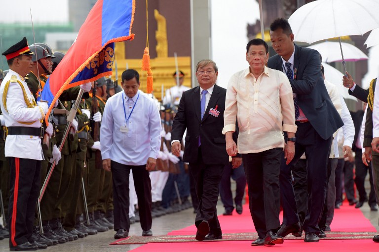 Philippines' President Rodrigo Duterte (2nd R) walks with Cambodia's Minister of Information Khieu Kanharith (3rd R) after paying respect to a statue of the late king Norodom Sihanouk in Phnom Penh on December 14, 2016. Duterte is on a two-day state visit to Cambodia. / AFP PHOTO / TANG CHHIN Sothy