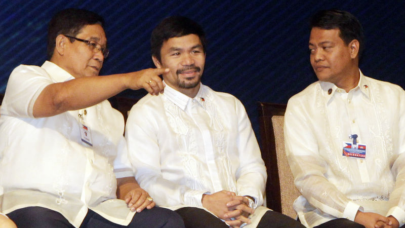 Philippine's boxer Manny Pacquiao, center, listens his President Rodrigo Duterte, unseen, during a meeting with the Filipino community, in Phnom Penh, Cambodia, Tuesday, Dec. 13, 2016. Duterte on Tuesday arrived Phnom Penh on his two-day official to Cambodia. (AP Photo/Heng Sinith)