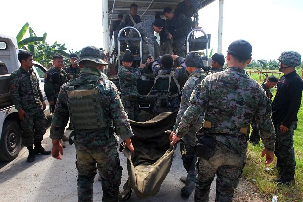 Philippine police commandoes load body bags containing the remains of their comrades killed in a clash with Muslim rebels, onto a truck in the town of Mamasapano, on the southern Philippine island of Mindanao on January 26, 2015.  Thirty police commandoes were feared dead after Philippine security forces clashed with Muslim rebels in the south, in rare violence that tested a nearly one-year-old peace accord, a rebel official said January 26.   AFP PHOTO / Mark Navales