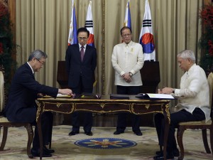 Philippine President Benigno Aquino III, second from right, and South Korean President Lee Myung-bak, second from left, look on during the signing of the Philippine-Korea Framework On Economic Development Cooperation Fund Loans agreement by South Korean Foreign Minister Kim Sung-hwan and Philippine Foreign Affairs Secretary Albert Rosario at the Malacanang palace in Manila, Philippines on Monday November 21, 2011. The two countries signed a total of five agreements during their meeting. (AP Photo/Aaron Favila)