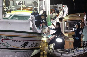 Taiwanese fisherman Hung Shih-cheng's boat, the Kuang Ta Hsing No. 28, is checked by Taiwanese officers after arriving at Liuqiu port in Pingtung County, southern Taiwan, Saturday, May 11, 2013. AP FILE PHOTO
