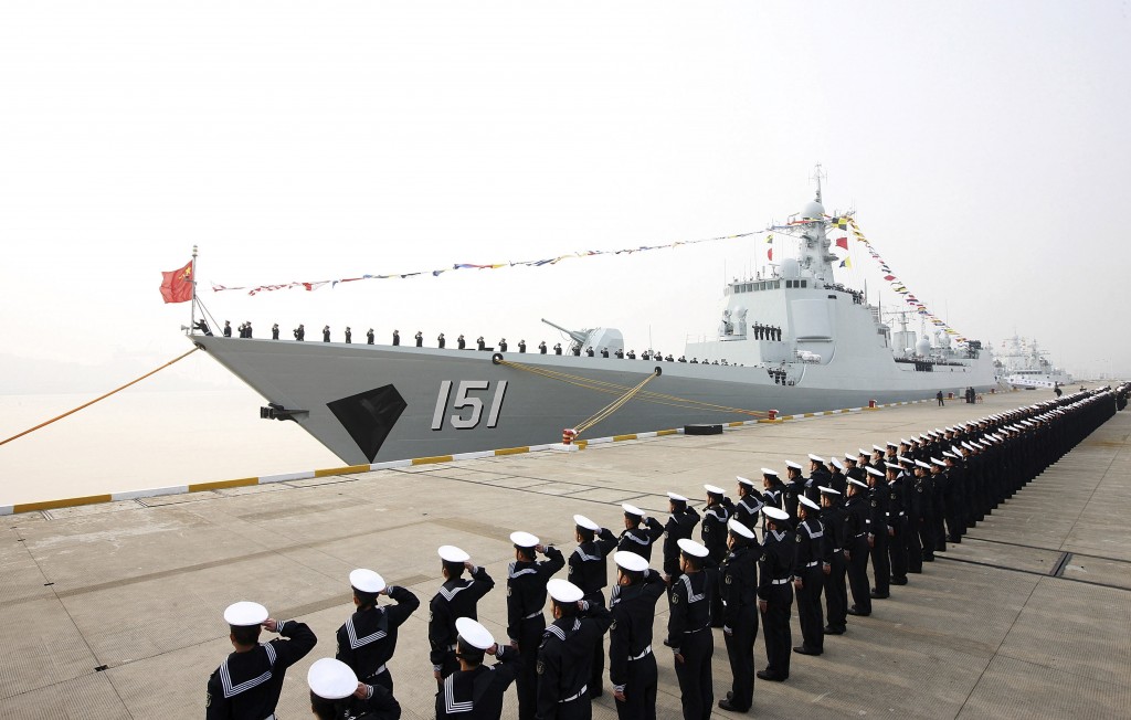 In this Dec. 26, 2013 photo, Chinese People's Liberation Army navy personnel salute in front of a new Type 052C guided missile destroyer Zhengzhou during its commission ceremony in Zhoushan, in eastern China's Zhejiang province. China is considering reorganizing its seven military regions into five to respond more swiftly to a crisis, the Japanese daily Yomiuri Shimbun reported.  AP PHOTO