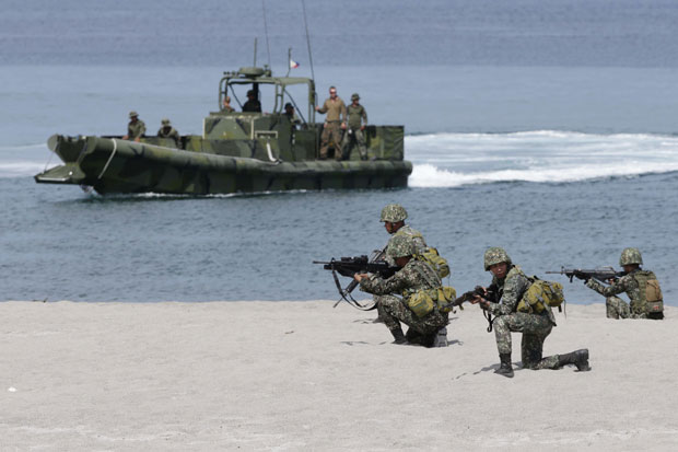 Philippine marines take their positions after being dislodged by a fast boat with their US counterpart during the joint U.S.-Philippines military exercise dubbed Balikatan 2014 Friday, May 9, 2014 at the Naval Training Exercise Command, a former US naval base, and facing the South China Sea at San Antonio township, Zambales province northwest of Manila, Philippines.AP (May 10, 2014)
