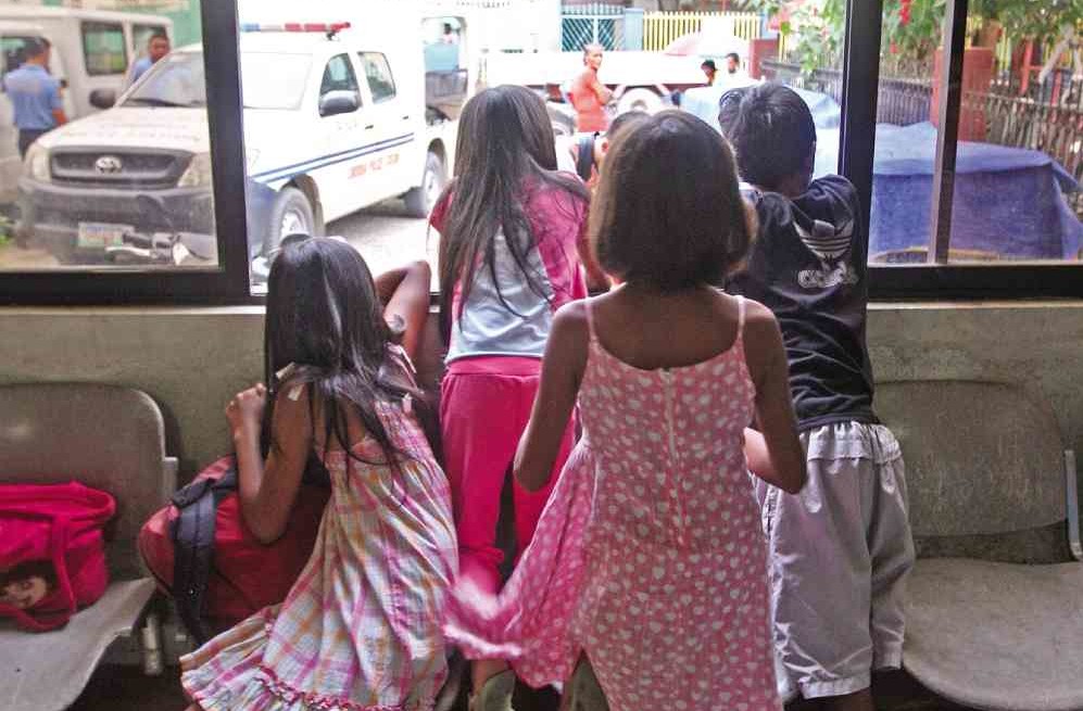 CHILDREN rescued by police look out a window of the Cordova police station, as officers file a complaint against an Australian tourist who allegedly preyed on them. TONEE DESPOJO/CEBU DAILY NEWS