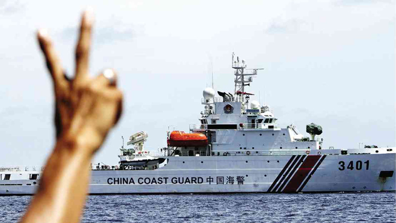 PEACE, MAN  A Philippine Marine soldier flashes the peace sign to a Chinese Coast Guard ship after it tried to block a resupply vessel from restocking the BRP Sierra Madre on Ayungin Shoal.  INQUIRER FILE PHOTO