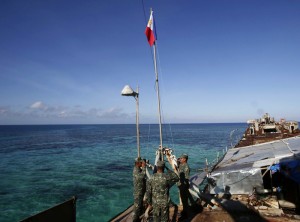 In this March 30, 2014, file photo, Philippine Marines raise the Philippine flag on the first day of their deployment on the dilapidated navy ship LT57 BRP Sierra Madre at the disputed Second Thomas Shoal, locally known as Ayungin Shoal, off the West Philippine Sea. The Philippines on Monday, Aug. 18, slammed what it called China’s “illegitimate sovereignty patrols” of Philippine waters, following President Aquino’s revelation that two Chinese research vessels had been spotted on oil-rich Recto Bank in the West Philippine Sea.  AP PHOTO/BULLIT MARQUEZ