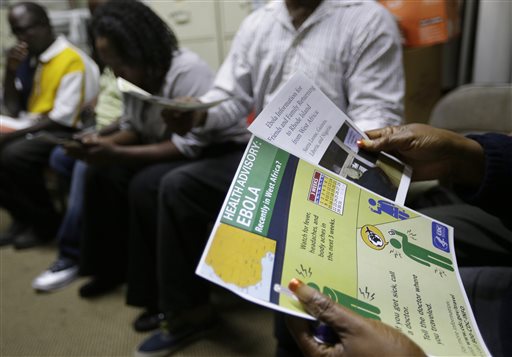 In this Wednesday, Oct. 8, 2014 photo, Araminta McIntosh, of Providence, R.I., hands only at right, holds informational flyers on Ebola during a meeting of the Liberian Community Association of Rhode Island, in Providence, R.I. AP FILE PHOTO