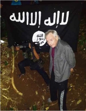 HEIGHTENED THREAT This photo provided by the Abu Sayyaf shows German scientist Viktor Stefan Okonek, 71, with an assault rifle pointed at his head at the terrorist group’s hideout somewhere in Sulu province.