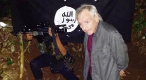 This photo provided by the Abu Sayyaf shows German scientist Viktor Stefan Okonek, 71, with an assault rifle pointed at his head at the terrorist group’s hideout somewhere in Sulu province.