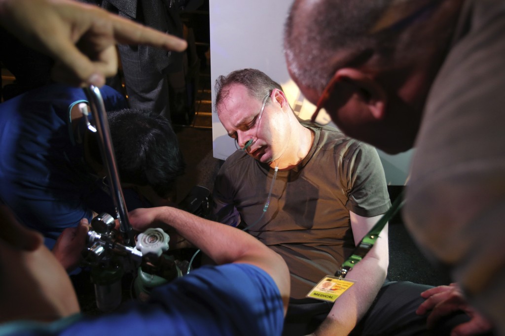 Medics attend to German national Marc Sueselbeck, fiance of slain transgender Filipino Jeffrey "Jennifer" Laude, after fainting following Bureau of Immigration officials' refusal to allow him to board his flight to Germany at Manila's International Airport, Philippines on Sunday Oct. 26, 2014.  AP PHOTO/AARON FAVILA 