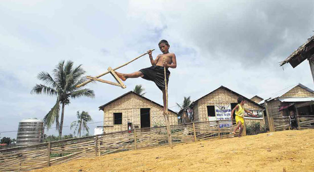 BOY ON STILTS  Reggie Macalla, 10, takes a giant step on his stilts (known locally as “kadang”) at a temporary shelter in Barangay Kawayan, Tacloban City. The village is one of the beneficiaries of WASH (Water, Sanitation and Hygiene) projects funded by Unicef and Action Contre la Faim.  EDWIN BACASMAS