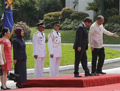 Philippine President Benigno Aquino III, right, gestures at Turkey's Prime Minister Ahmet Davutoglu during a welcoming ceremony Monday, Nov. 17, 2014 at Malacanang Palace grounds in Manila, Philippines. AP