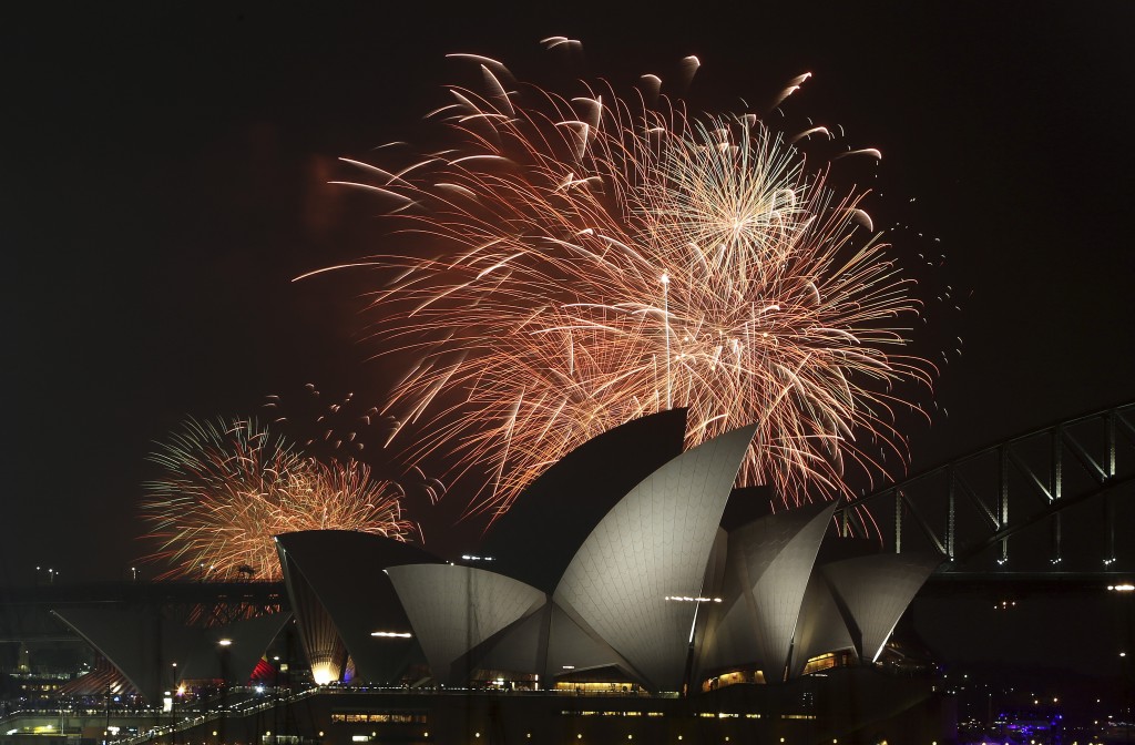Fireworks explode over the Opera House and the Harbour Bridge during New Year’s Eve celebrations in Sydney, Australia, Wednesday, Dec. 31, 2014. Thousands of people crammed into Lady Macquaries Chair to watch the annual fireworks show.  AP PHOTO/ROB GRIFFITH