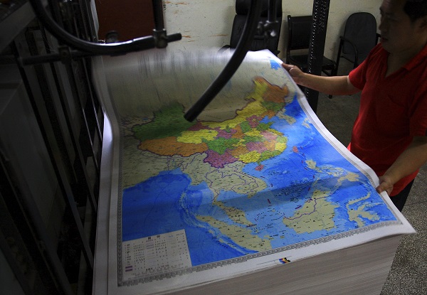 In this June 27, 2014 photo, a printing worker holds a new officially approved map of China that includes the islands and maritime area that Beijing claims in the South China Sea, at a factory in Changsha in south China's Hunan province. China has again rejected an attempt by the Philippines to challenge its territorial claims over the South China Sea through international arbitration, releasing a lengthy paper a week before the Dec. 15, 2014 deadline for China to respond to the case. China prefers to settle its disputes with discussions with the countries directly involved. But the Philippines has filed a case with an international tribunal. AP