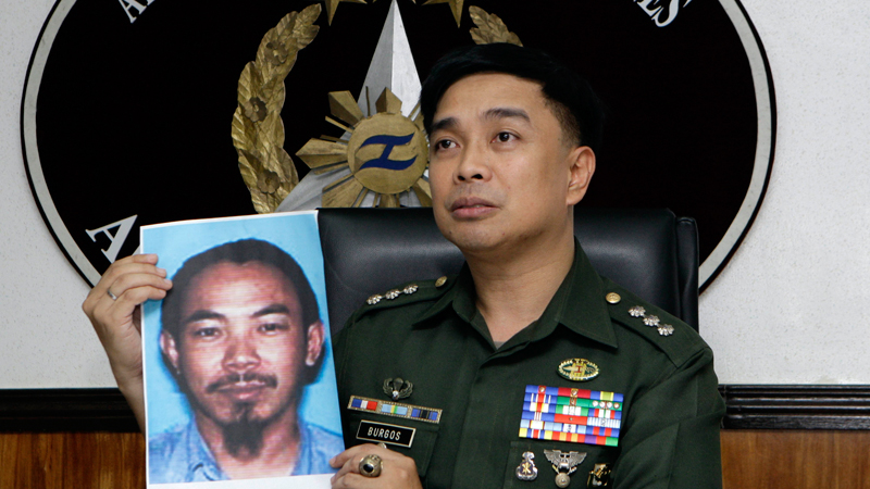 In this Feb. 2, 2012 file photo, then Armed Forces of the Philippines spokesman Col. Marcelo Burgos shows a picture of Malaysian Zulkifli bin Hir, also known as Marwan, during a press conference in suburban Quezon City, north of Manila, Philippines. Southeast Asia's top terrorist suspect has evaded capture and survived several military assaults in the southern Philippines, where police now await DNA results to confirm if he is the man killed in the Jan. 25, 2015 raid that also left 44 police commandos dead. (AP Photo/Pat Roque, File)