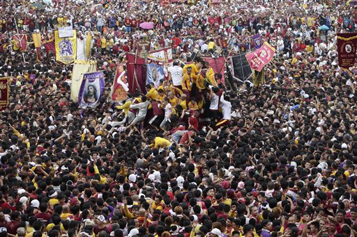 In this Jan. 9, 2015, photo, Filipino devotees carry the image of the Black Nazarene for its annual procession to celebrate its feast day in Manila. The raucous celebration drew tens of thousands of devotees which local newspapers headlined as a "dry run" for Pope Francis' visit in Manila. With his man-of-the people reputation, Pope Francis could attract one of the biggest gatherings ever for a Pope during an open-air Mass in Rizal Park on Jan. 18.  AP Photo/Bullit Marquez 
