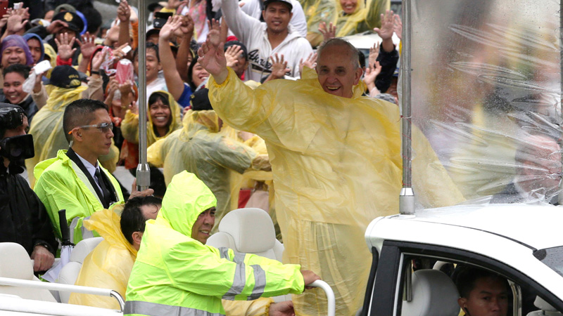 Pope Francis waves as he leaves Tacloban, Philippines, Saturday, Jan. 17, 2015. Francis cut short his day trip to ground zero of the devastating 2013 Typhoon Haiyan to avoid another approaching storm, but not before consoling survivors at a rain-drenched outdoor mass. (AP Photo/Bullit Marquez)