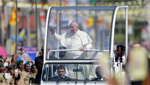 Pope Francis waves to people waiting on a road to welcome him on the outskirts of Colombo, Sri Lanka, Tuesday, Jan. 13, 2015. Pope Francis arrived in Sri Lanka Tuesday at the start of a weeklong Asian tour saying the island nation can't fully heal from a quarter-century of ethnic civil war without pursuing truth for the injustices committed. AP