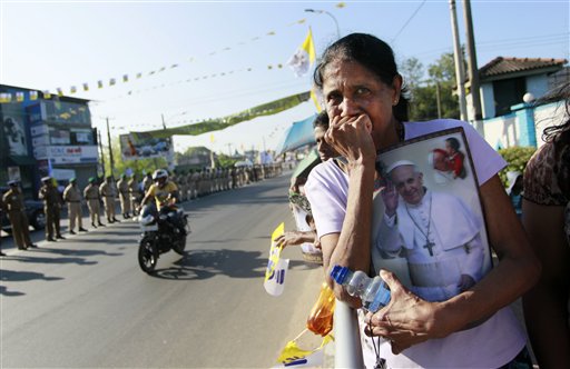 A Sri Lankan Catholic holds a portrait of Pope Francis and awaits his arrival, on the outskirts of Colombo, Sri Lanka, Tuesday, Jan. 13, 2015. Less than a week after its longtime president was surprisingly voted out of office, Sri Lanka welcomes Pope Francis on Tuesday, with the island nation's Catholic minority hoping he can help heal the lingering wounds of the country's 25-year civil war. Catholics make up slightly more than 6 percent of Sri Lanka's population of 21 million, according to the government. AP