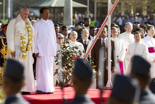 Pope Francis, left,  and Sri Lankan President Maithripala Sirisena, second left, listen to the national anthems during the welcome ceremony in Colombo, Sri Lanka, Tuesday, Jan. 13, 2015.  AP