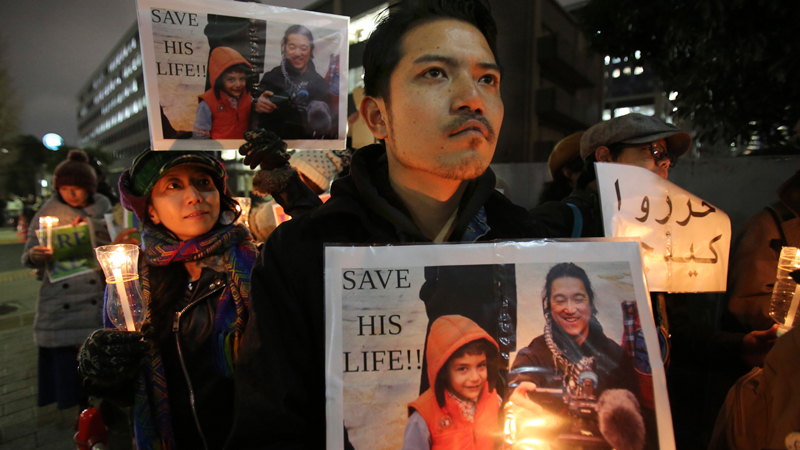  In this Friday, Jan. 30, 2015 file photo, protesters holding signs bearing a photo of Japanese journalist Kenji Goto who was taken hostage by the Islamic State group appeal the government to save Goto during a rally in front of the prime minister's official residence in Tokyo. Whether in tsunami-stricken northeastern Japan or conflict-ridden Sierra Leone, it was the story of the vulnerable, the children and the poor that drove the work of Goto. The news of his killing in a video purportedly by Islamic State militants sent Japan into shock and mourning Sunday, Feb. 1, days after his plight as a hostage in Syria united many people in praying for his release. (AP Photo/Koji Sasahara, File)