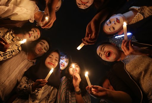 Indonesian activists hold candles during a candle light vigil marking Earth Hour, in the main business district in Jakarta, Indonesia, Saturday , March 28, 2015. AP
