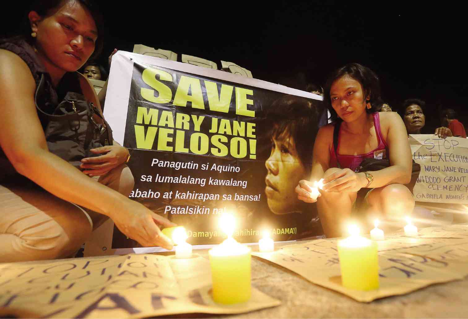 VIGIL FOR VELOSO  Women activists light candles for Mary Jane Veloso, a Filipino migrant worker facing execution by firing squad for drug trafficking in Indonesia, during a vigil on the University of the Philippines campus in Diliman, Quezon City, on Sunday.  MARIANNE BERMUDEZ