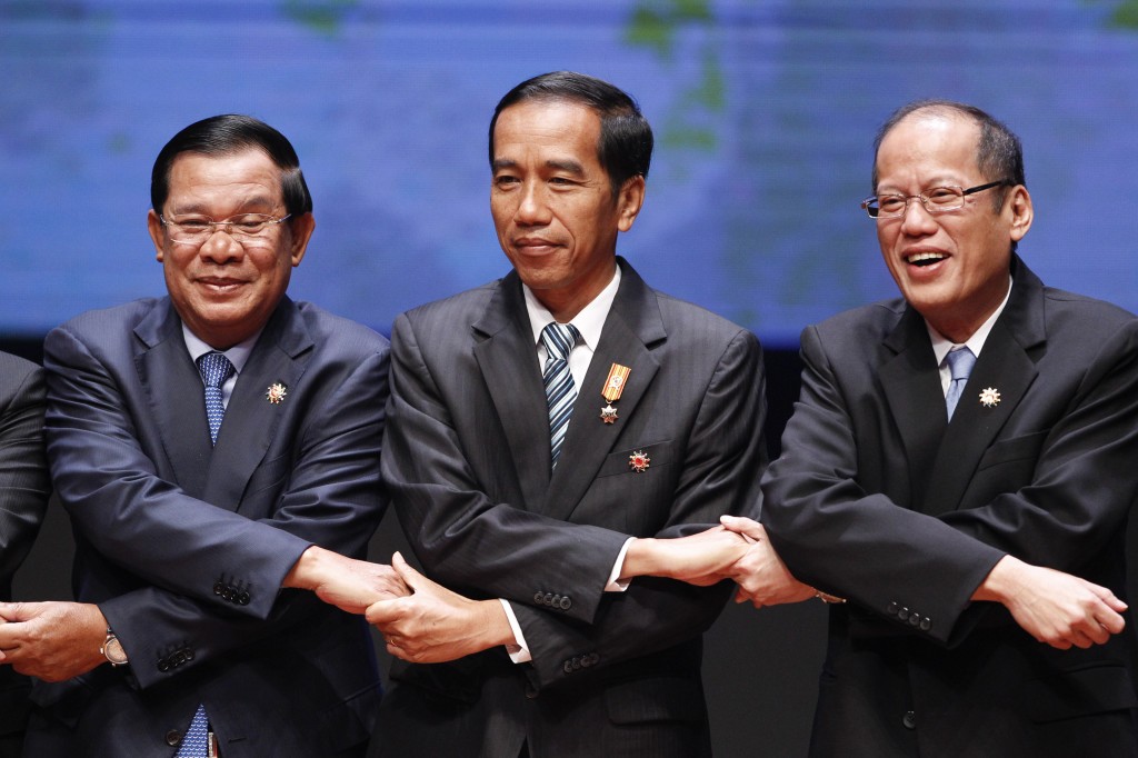 From left to right, Cambodia's Prime Minister Hun Sen, Indonesia's President Joko Widodo, and Philippine's President Benigno Aquino III join their hands during the opening ceremony of the 26th ASEAN Summit in Kuala Lumpur, Malaysia, on Monday, April 27, 2015. (AP Photo) 