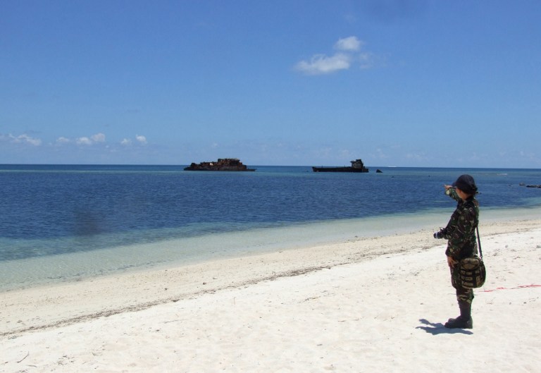 In this photograph taken in June 2014 a military personnel stands on the beach on Pag-asa Island  which hosts a small Filipino town as well as an airstrip used for civilian and military flights in the disputed Spratly islands in the South China sea. AFP