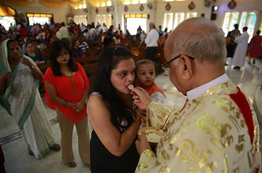 Indian Christians receive Holy Communion from a priest after Easter mass at a Church in Mumbai, India, Sunday, April 5, 2015. Christians around the world are celebrating Easter commemorating the day when according to Christian tradition Jesus was resurrected in Jerusalem two millennia ago. AP