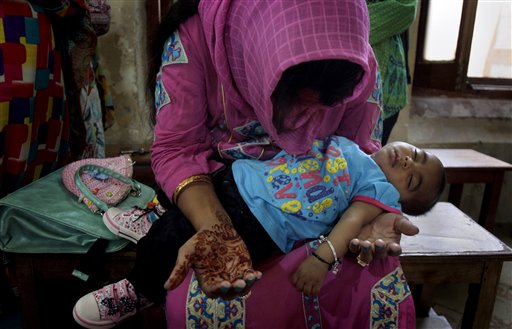 A Christian woman holds her child while she prays during Easter service at St. Oswald's Church in Lahore, Pakistan, Sunday, April 5, 2015. Christians across the world are celebrating Easter, commemorating the day followers believe Jesus was resurrected in Jerusalem over 2,000 years ago. AP